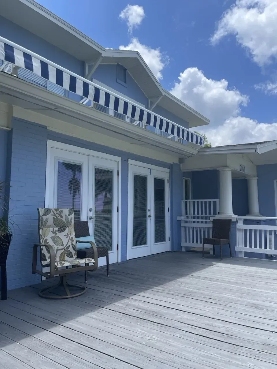 The sunny exterior of The Wave treatment center, a coastal blue home with a private sun deck